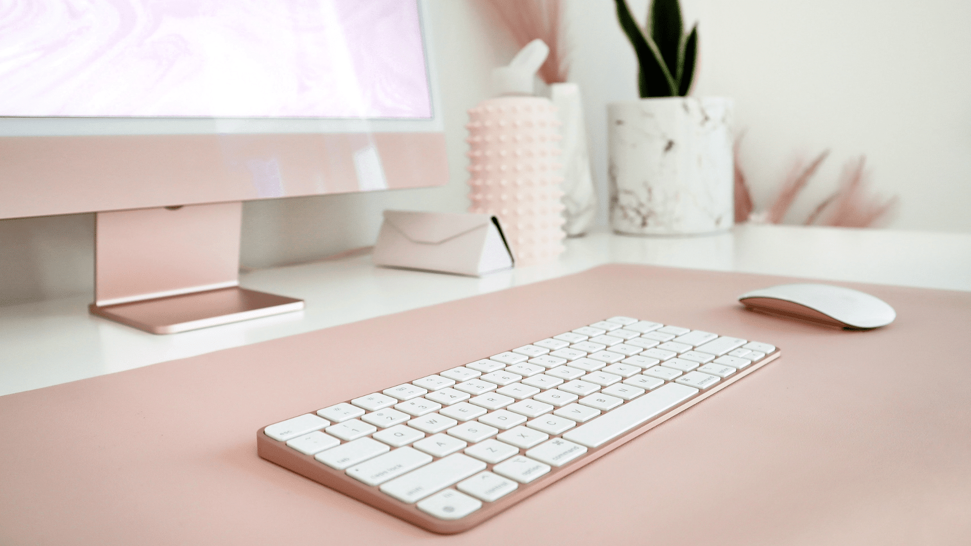Un clavier posé sur un bureau rose pour l'article L’importance de votre identité visuelle sur Instagram avec Polina Polozyuk